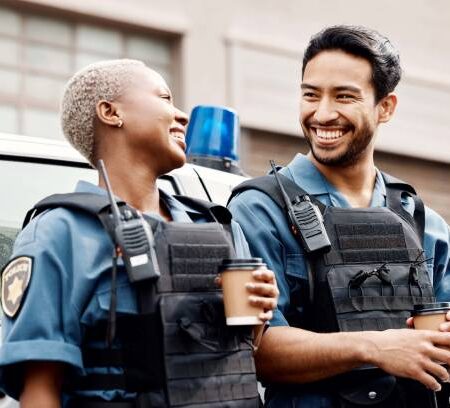 istockphoto-2154004980-612x612 Lunch, team or police officers in city for protection, law enforcement or crime on a break together. Coffee, funny policeman or happy woman security guard laughing or standing for justice or teamwork