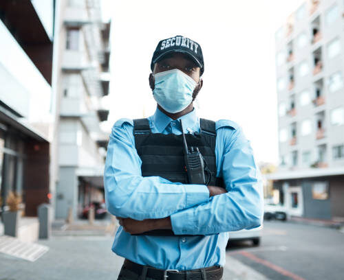 Portrait of a confident masked young security guard standing guard outdoors Portrait of a confident masked young security guard standing guard outdoors