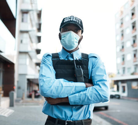 Portrait of a confident masked young security guard standing guard outdoors Portrait of a confident masked young security guard standing guard outdoors