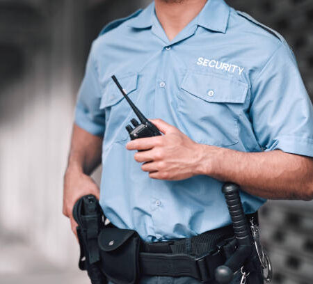 s13 Security guard, safety officer and man with walkie talkie in hand on street for protection, patrol or watch. Law enforcement, focus and duty with a crime prevention male worker in uniform in the city